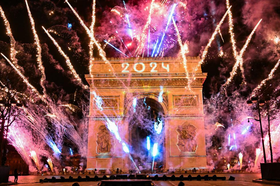 Los fuegos artificiales explotan junto al Arco de Triunfo con la palabra "2024" proyectada, en la Avenida de los Campos Elíseos, durante las celebraciones del Año Nuevo en París, Francia, a primera hora del 1 de enero de 2024. (Foto de Bertrand GUAY / AFP). / BERTRAND GUAY