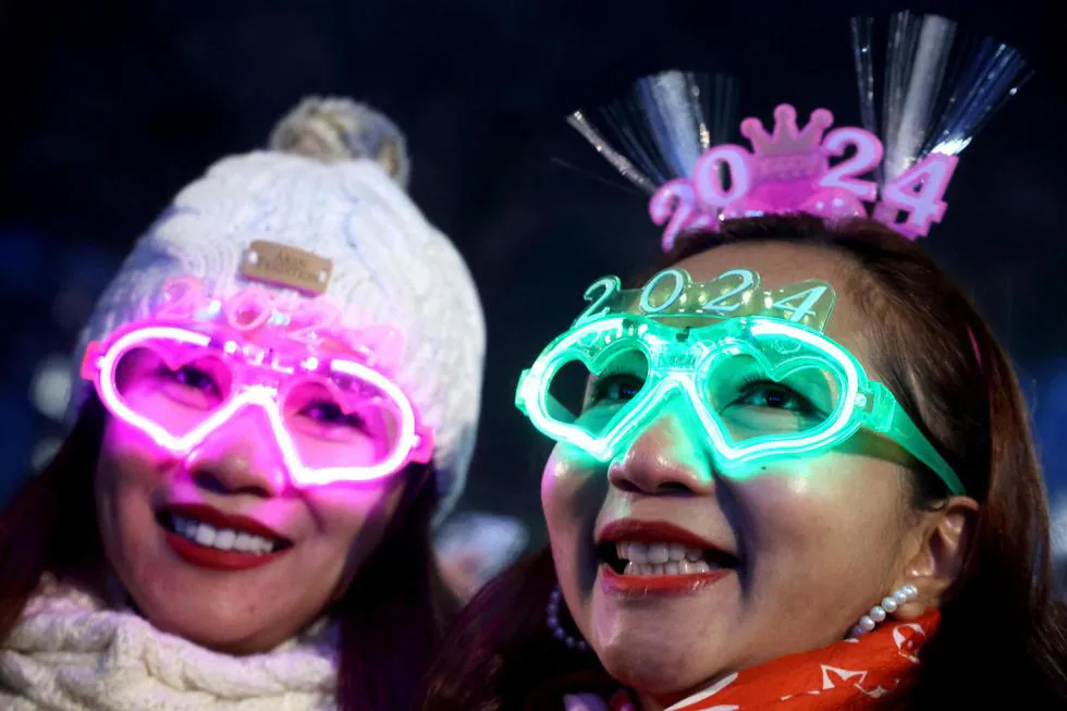 Los juerguistas usan gafas 2024 durante las celebraciones con fuegos artificiales por la llegada del Año Nuevo en el río Támesis, en Londres, Gran Bretaña. (EFE/EPA/NEIL HALL). / NEIL HALL