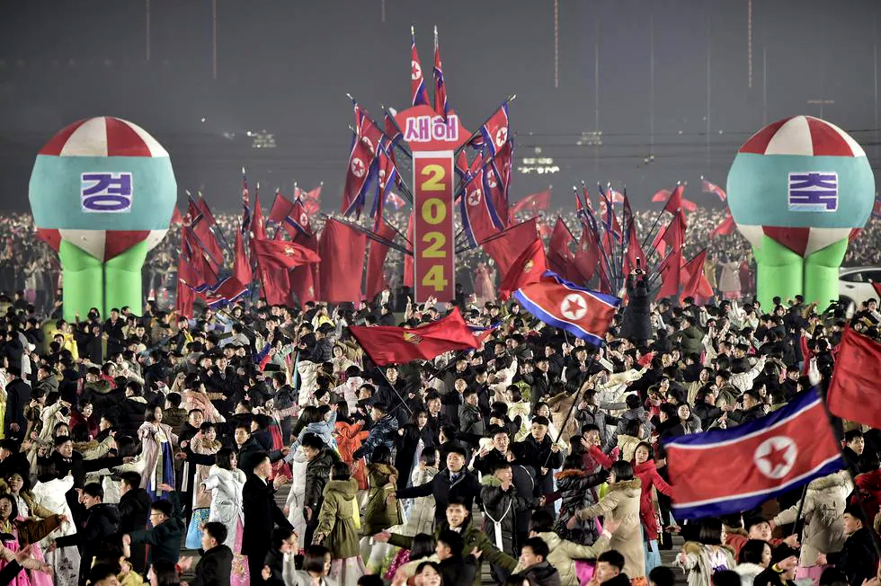 Jóvenes y estudiantes participan en las celebraciones para dar la bienvenida al nuevo año en la plaza Kim Il-sung en Pyongyang el 31 de diciembre de 2023. (Foto de KIM Won Jin / AFP). / KIM WON JIN